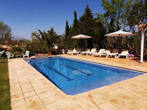 einen Pool mit Stühlen und Sonnenschirmen im Hof in der Unterkunft Casa Caldes de Malavella, 5 dormitorios, 10 personas - ES-209-37 in Caldes de Malavella