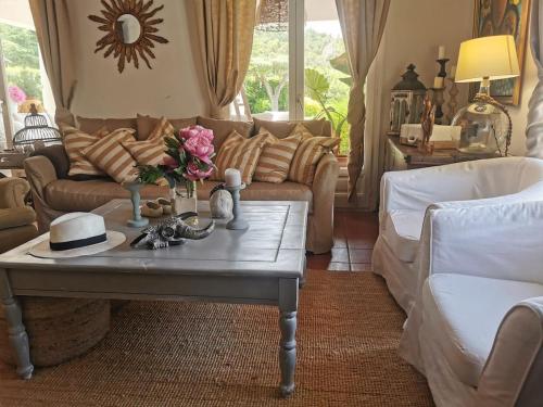 een woonkamer met een bank en een tafel met bloemen erop bij Casa Caldes de Malavella, 5 dormitorios, 10 personas - ES-209-37 in Caldes de Malavella