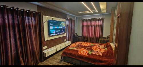 1 dormitorio con 1 cama, TV y cortinas en Home sleeper en Srinagar