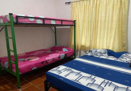 2 literas están en una habitación con 3 camas individuales que establecen que en Casa Finca Kilometro 28 Bitaco, en La Cumbre