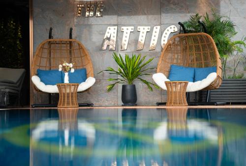 two chairs with blue pillows sitting next to a swimming pool at Northern Charm Hotel in Ho Chi Minh City