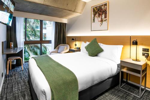 a hotel room with a large bed and a window at Song Hotel Sydney in Sydney