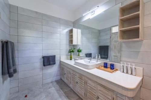 a bathroom with a sink and a mirror at Hibiscus Home&Apartments in Galu