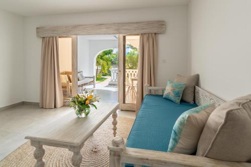 uma sala de estar com um sofá e uma mesa em Hibiscus Home&Apartments em Galu