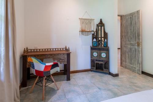 a room with a desk and a chair and a fireplace at Hibiscus in Diani Beach