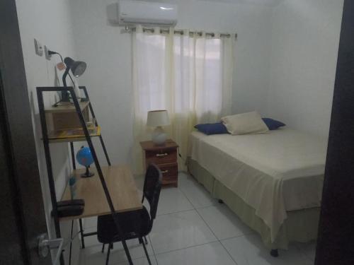 um quarto com uma cama e uma secretária com um candeeiro em MADDY Free Wi-Fi, AC in ea Bedrooms, Private Community! em San Miguel