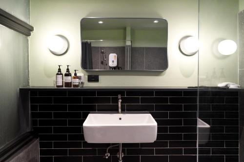 a bathroom with a white sink and a mirror at Theme Stories - Boutique Guesthouse in Bangkok