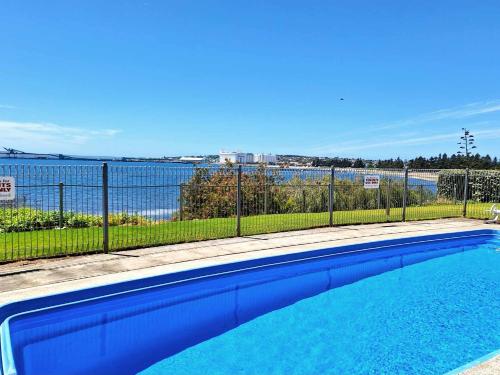 a swimming pool with a view of the water at ON THE WATERS EDGE in Port Lincoln
