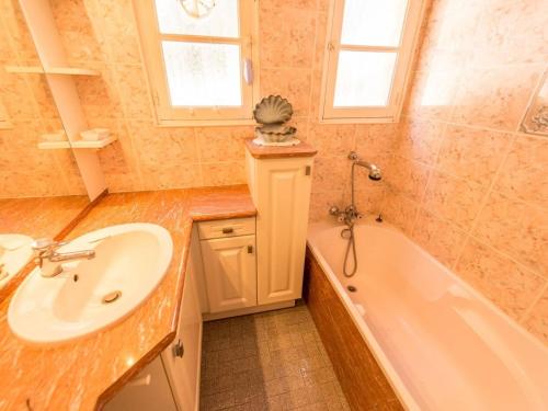 une salle de bain avec un lavabo et une baignoire dans l'établissement Villa 3 chambres avec piscine privée, véranda et jardin près des plages - FR-1-768-16, aux Issambres