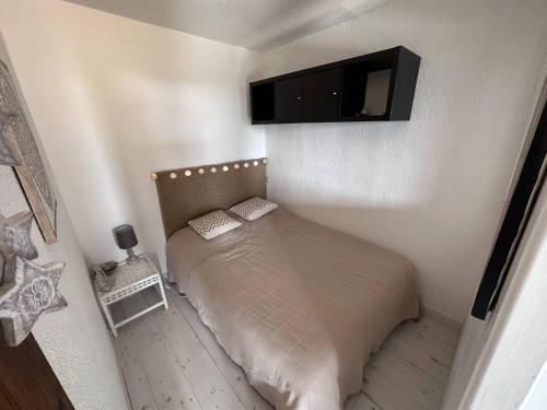 - une chambre avec un lit et une télévision murale dans l'établissement Appartement T2 proche mer avec piscine et parking - FR-1-768-23, aux Issambres