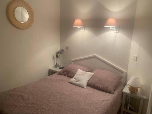 - une chambre avec un lit, deux lampes et un miroir dans l'établissement Appartement T2 climatisé avec piscine, proche plage, port, commerces et parking privé - FR-1-768-15, aux Issambres