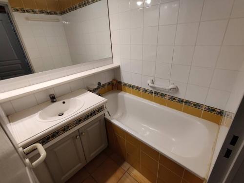 une salle de bain avec une baignoire, un lavabo et un miroir dans l'établissement Appartement T2 climatisé avec piscine, proche plage, port, commerces et parking privé - FR-1-768-15, aux Issambres
