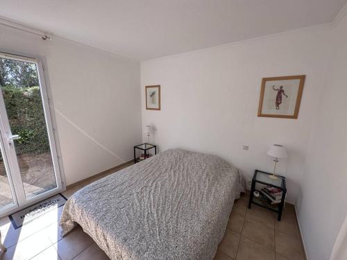 une chambre blanche avec un lit et une fenêtre dans l'établissement Appartement T2 avec jardin, piscine et parking aux Issambres, proche mer - FR-1-768-34, aux Issambres