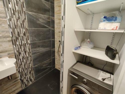 La petite salle de bains est pourvue d'un lave-linge et d'une douche. dans l'établissement Ravissant T2 avec piscine, climatisation et parking - Proche plages et port - FR-1-768-19, aux Issambres