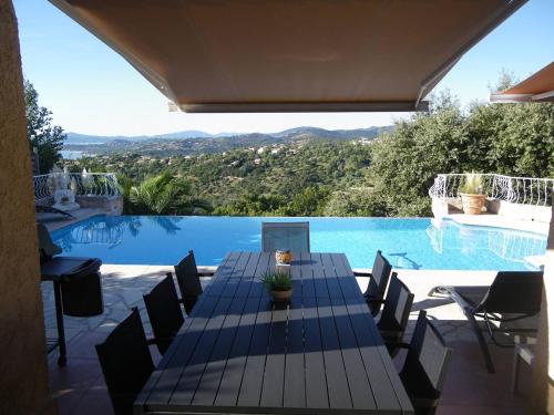 - une table à manger et des chaises à côté de la piscine dans l'établissement Villa avec piscine privée, climatisation et parking aux Issambres - FR-1-768-26, aux Issambres