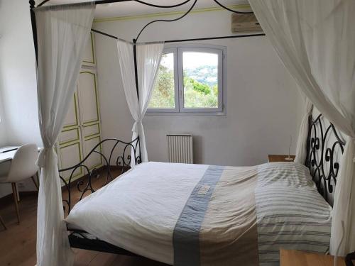 ein Schlafzimmer mit Himmelbett und Fenster in der Unterkunft Grande villa 6 chambres avec piscine privée chauffée, vue mer, climatisation et jardin - FR-1-768-31 in Les Issambres