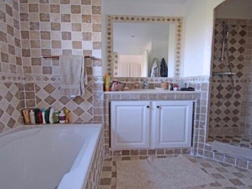 une salle de bain avec une baignoire, un lavabo et un miroir dans l'établissement Villa 4* pour 10 pers avec piscine privée, clim, parking, proche plage - FR-1-768-35, aux Issambres