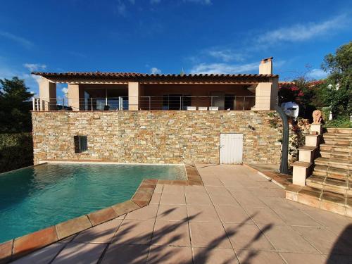 une maison avec une piscine devant une maison dans l'établissement Villa 4* pour 10 pers avec piscine privée, clim, parking, proche plage - FR-1-768-35, aux Issambres