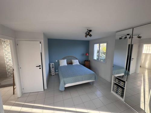 une chambre avec un lit et un mur bleu dans l'établissement Villa contemporaine 8/9 pers avec piscine & clim proche plages - 4 étoiles - FR-1-768-43, aux Issambres