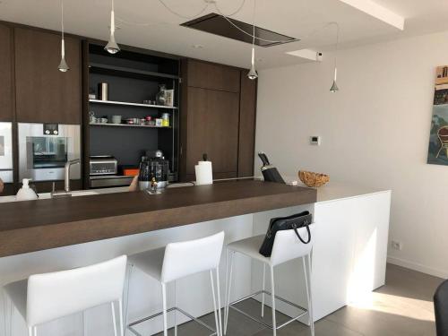 une cuisine avec un bar et des tabourets blancs dans l'établissement Villa Californienne avec Piscine Privée et Climatisation - FR-1-768-37, aux Issambres