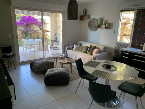 un salon avec un canapé, une table et des chaises dans l'établissement Grand T3 aux Issambres avec jardin, proche mer et commerces - FR-1-768-48, aux Issambres