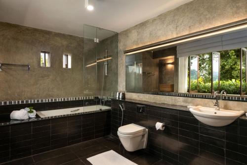 W łazience znajduje się umywalka, toaleta i lustro. w obiekcie Mount Havana w mieście Kandy