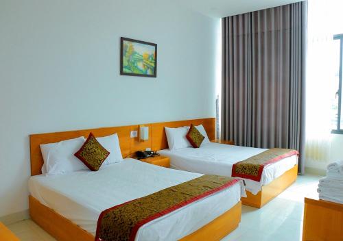 a hotel room with two beds and a window at Khách sạn Phố Ngọc in Nha Trang
