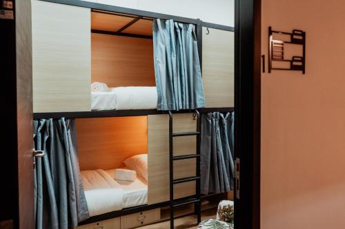 a room with two bunk beds and a ladder at Code Hostel Singapore in Singapore