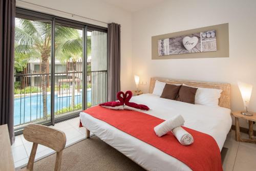 a bedroom with a bed with a red blanket at LUX APPARTMENT GOLF DE MONT CHOISY in Mont Choisy
