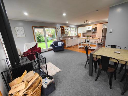 a kitchen and living room with a table and chairs at Peaceful by the Park in Invercargill