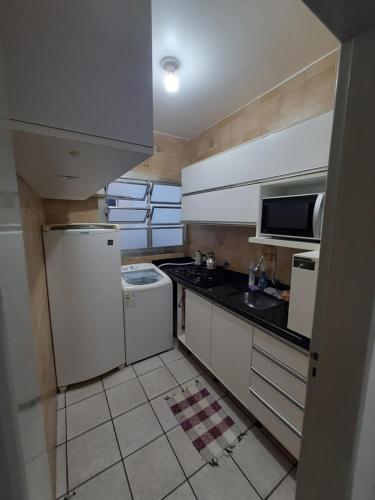 a kitchen with a white refrigerator and a sink at Capao Canoa - Próximo Mar Centro in Capão da Canoa