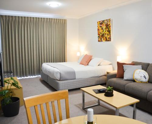 una camera d'albergo con letto e divano di Mansfield Apartments a Mansfield