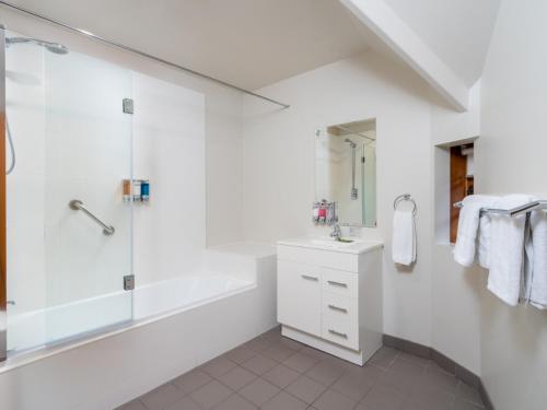 a white bathroom with a shower and a sink at Leisure Inn Penny Royal Hotel & Apartments in Launceston
