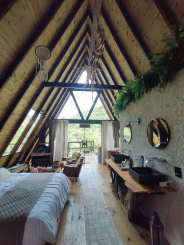 ein Schlafzimmer mit einem Bett und einem Waschbecken in einem Zimmer in der Unterkunft Chalé Alcântara in São Pedro de Alcântara