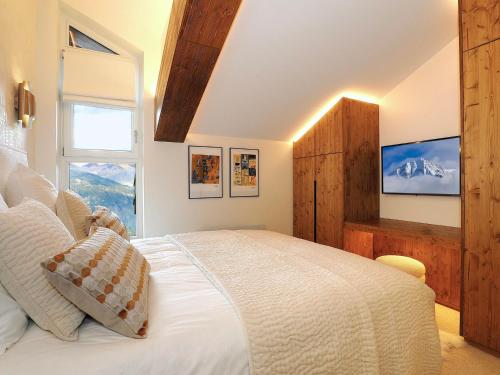 une chambre avec un grand lit blanc avec une fenêtre dans l'établissement Appartement duplex à Courchevel 1850 - 6 pers, 3 chambres, centre station - FR-1-564-116, à Courchevel