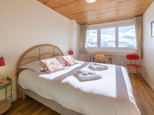 une chambre avec un lit avec des draps blancs et une fenêtre dans l'établissement Appartement rénové avec balcon | WIFI | Casier à skis - FR-1-645-50, à Huez