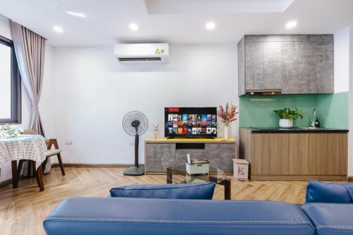 a living room with blue couches and a tv at Westlake Emerald Suites in Hanoi