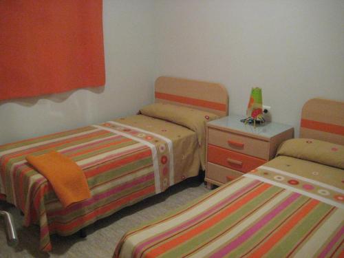 1 dormitorio con 2 camas, vestidor y falda en Apartamento Illa Mar, en Sant Carles de la Ràpita