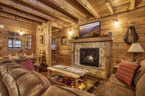 a living room with a fireplace in a log cabin at Bridgewood Cabin, Hot Tub, FREE Attraction tickets, WIFI!!! in Pigeon Forge