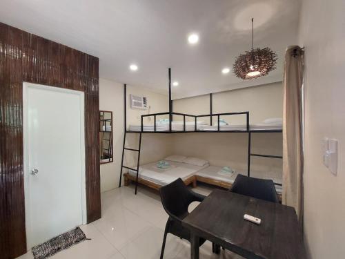 a room with a table and two bunk beds at Avila's Horizon Dive Resort Malapascua in Malapascua Island