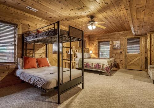 a bedroom with two bunk beds in a log cabin at Bridgewood Cabin, Hot Tub, FREE Attraction tickets, WIFI!!! in Pigeon Forge