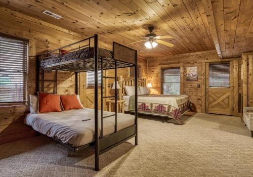 a bedroom with two bunk beds in a log cabin at Bridgewood Cabin- New Listing - Hot Tub, Pool Table, Free Attraction Tickets in Pigeon Forge