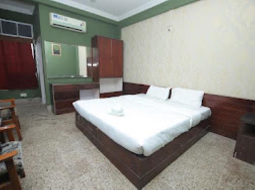 ein Schlafzimmer mit einem großen weißen Bett in einem Zimmer in der Unterkunft HOTEL EAST INN DIMAPUR in Dimapur