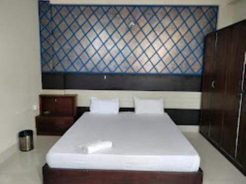 HOTEL EAST INN DIMAPUR في ديمابور: غرفة نوم بسرير كبير مع مرتبة بيضاء