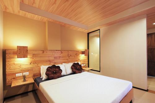 a bedroom with a large white bed and a mirror at GHIELLANIQA INN in San Nicolas