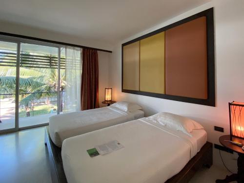 Habitación de hotel con 2 camas y ventana grande. en VANA Wellness Resort, 