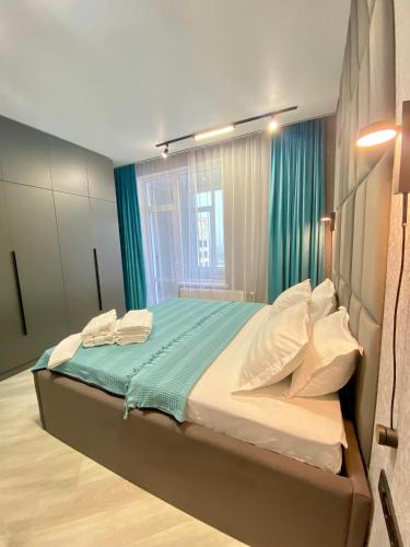 1 dormitorio con 1 cama grande y cortinas verdes en Landmark Astana 2 комнатные апартаменты en Astaná