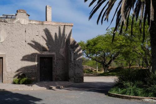 an old stone building with a shadow of a tree at Viñedo Bodega 1881 in Santa Ana