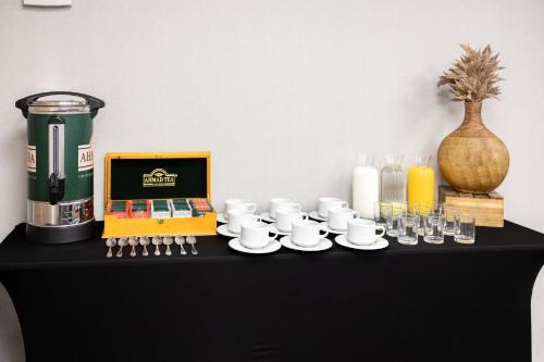 a black table with cups and saucers and glasses at Holiday Inn Express - Iquique by IHG in Iquique