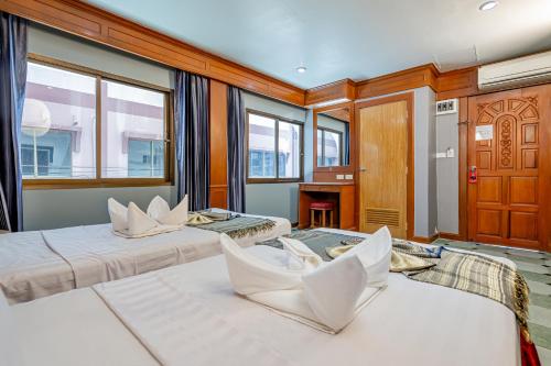 Duas camas num quarto grande com janelas em Patong Social Hotel & Restaurant em Patong Beach